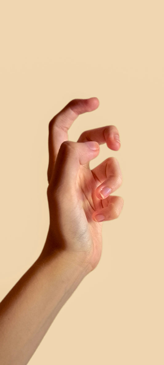 A person's hand reaching up towards the sky